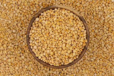 Bezelye desenli ahşap bir tabakta çiğ sarı bezelye.