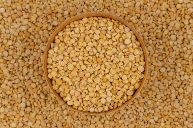 Bezelye desenli ahşap bir tabakta çiğ sarı bezelye.