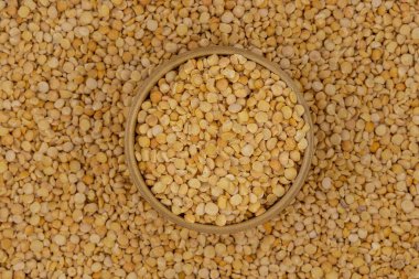 Bezelye desenli ahşap bir tabakta çiğ sarı bezelye.