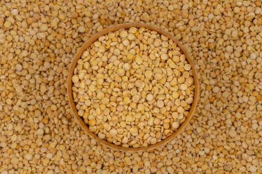 Bezelye desenli ahşap bir tabakta çiğ sarı bezelye.