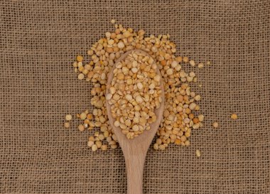 Çuval bezi desenli sarı bezelyeli ahşap kaşık.