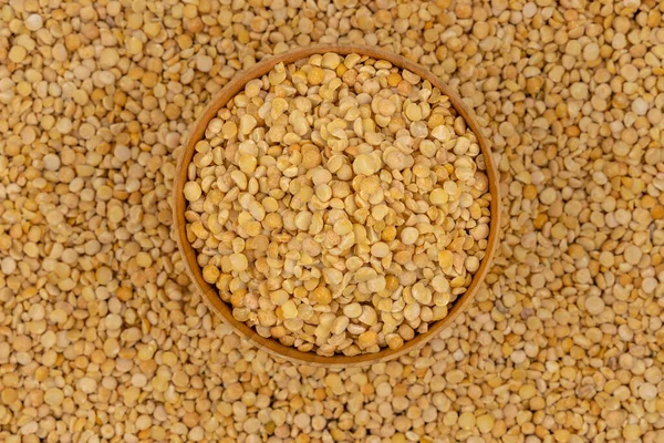 Bezelye desenli ahşap bir tabakta çiğ sarı bezelye.