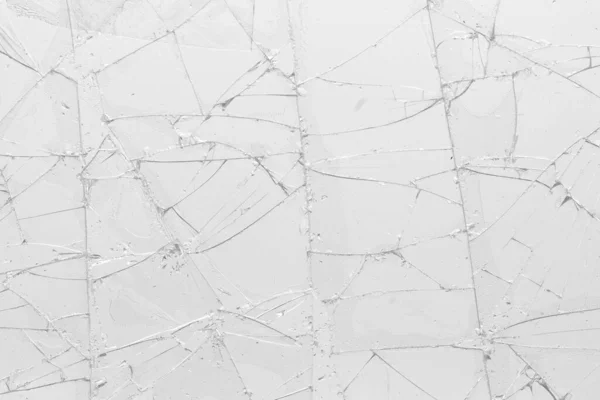 White cracked glass texture background. Texture broken glass window with cracks. Broken screen.