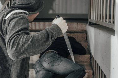 Bıçaklı bir adam sahanlıkta bir adamı öldürmeye çalışıyor. Şiddet ve cinayet konuları. Hırsız, katil, tecavüzcü, manyak, hırsız