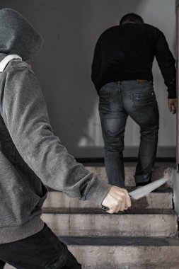 Bıçaklı bir adam sahanlıkta bir adamı öldürmeye çalışıyor. Şiddet ve cinayet konuları. Hırsız, katil, tecavüzcü, manyak, hırsız