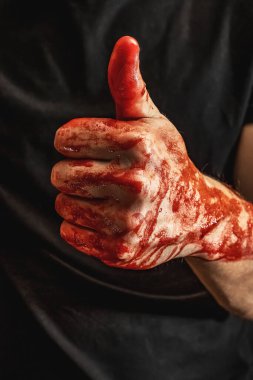 Siyah arka plandaki kanda çeşitli jestler gösteren erkek elleri. Kanla başparmak yukarı.