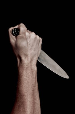 Adamın eli siyah arka planda bir bıçak tutuyor. Şiddet ve cinayet konuları. Hırsız, katil, tecavüzcü, manyak