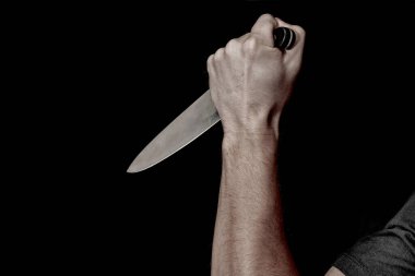 Adamın eli siyah arka planda bir bıçak tutuyor. Şiddet ve cinayet konuları. Hırsız, katil, tecavüzcü, manyak