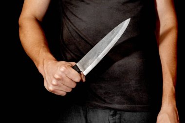 Adamın eli siyah arka planda bir bıçak tutuyor. Şiddet ve cinayet konuları. Hırsız, katil, tecavüzcü, manyak