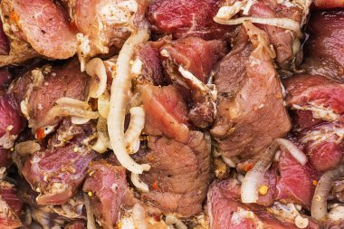 Şiş kebap için soğan ve baharatla terbiye edilmiş taze et parçaları, salamura et, yakın plan, arka plan dokusu.