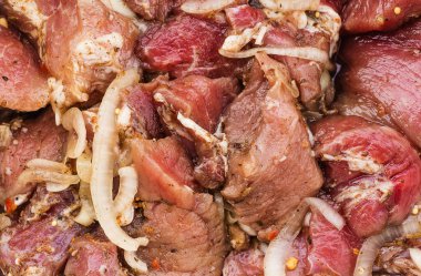 Şiş kebap için soğan ve baharatla terbiye edilmiş taze et parçaları, salamura et, yakın plan, arka plan dokusu.