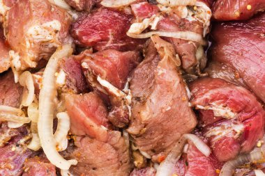 Şiş kebap için soğan ve baharatla terbiye edilmiş taze et parçaları, salamura et, yakın plan, arka plan dokusu.