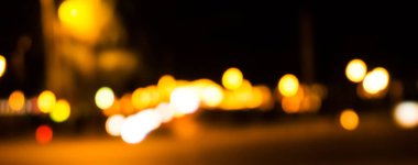 Bokeh şehrin dokusunun gece sokaklarını aydınlatıyor. Retro tonlu bulanık ışıklar, kentsel soyut arkaplan.