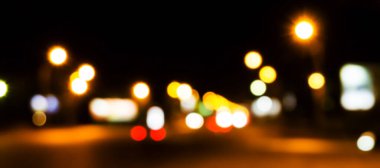 Bokeh şehrin dokusunun gece sokaklarını aydınlatıyor. Retro tonlu bulanık ışıklar, kentsel soyut arkaplan.