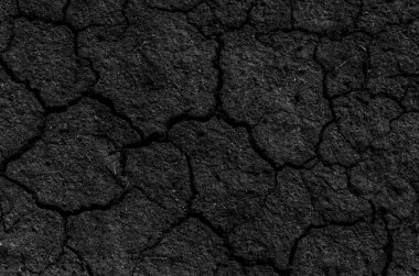 Siyah çatlamış gri toprak dokusu arka plan, koyu ve doğranmış gri toprak, eski çatlak karanlık zemin, yakın plan, erozyon