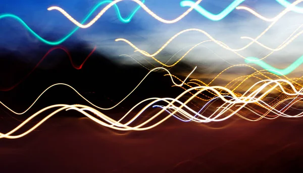 Bokeh şehrin dokusunun gece sokaklarını aydınlatıyor. Retro tonlu bulanık ışıklar, kentsel soyut arkaplan.