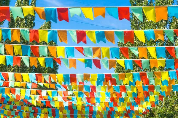 Mavi Gökyüzüne Ağaçlara Karşı Çok Renkli Bayraklar Üçgen Şeklinde Şehir — Stok fotoğraf