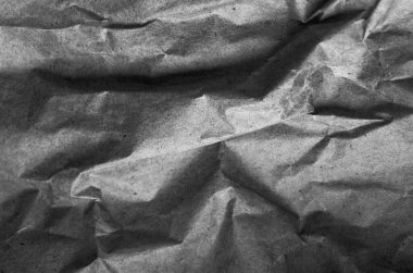 Siyah buruşuk ambalaj kâğıdı arka planı, eski antika kağıdın gri kırışık dokusu, koyu kağıt yüzeyinde kırışıklıklar.