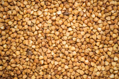 Olgun karabuğday arka planda inliyor, doğal karabuğday taneleri yakın planda.