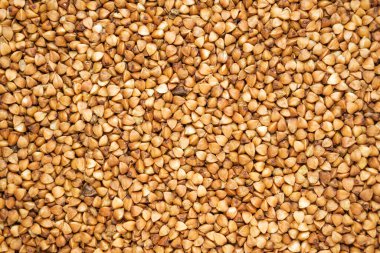 Olgun karabuğday arka planda inliyor, doğal karabuğday taneleri yakın planda.