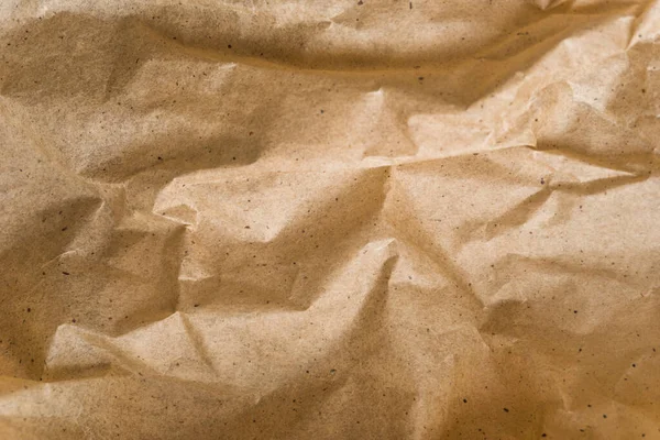 Kahverengi ambalaj kağıdı arka planı, sarı kırışık eski kağıt, kağıt yüzeyinde kırışıklıklar.