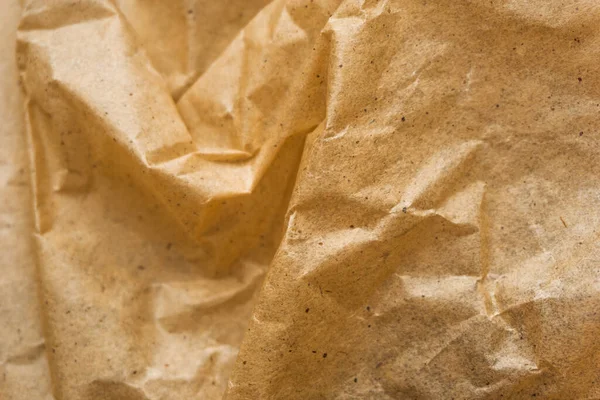 Kahverengi ambalaj kağıdı arka planı, sarı kırışık eski kağıt, kağıt yüzeyinde kırışıklıklar.