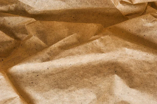 Kahverengi ambalaj kağıdı arka planı, sarı kırışık eski kağıt, kağıt yüzeyinde kırışıklıklar.