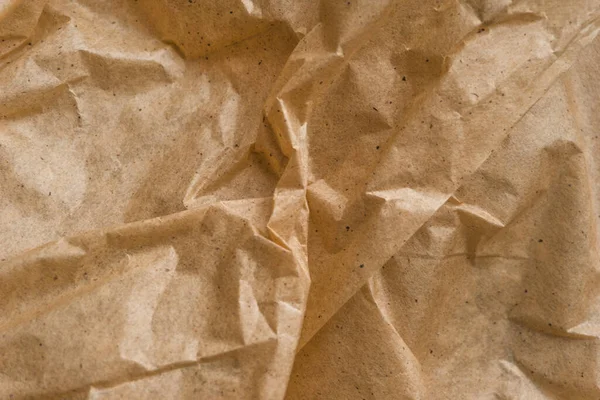 Brown crumpled wrapping paper background, texture of yellow wrinkled of old vintage paper, creases on the surface of paper