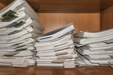 Belgeler arşivde duruyor. Belgeler arşiv odasının raflarında. Ofis rafları dosyalarla dolu dolapta.