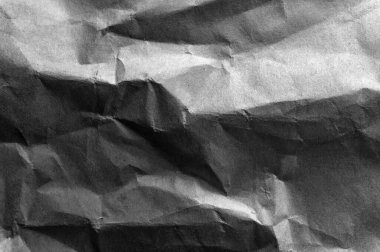 Siyah buruşuk ambalaj kâğıdı arka planı, eski antika kağıdın gri kırışık dokusu, koyu kağıt yüzeyinde kırışıklıklar.