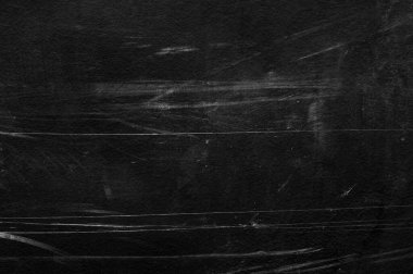 Beyaz çizikler ve aşınma dokusu olan eski siyah bir duvar. tebeşirle desenli grunge siyah tahta