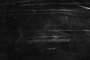 Beyaz çizikler ve aşınma dokusu olan eski siyah bir duvar. tebeşirle desenli grunge siyah tahta