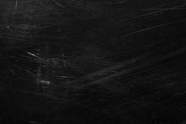 Beyaz çizikler ve aşınma dokusu olan eski siyah bir duvar. tebeşirle desenli grunge siyah tahta
