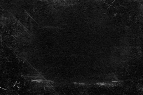 Beyaz çizikler ve aşınma dokusu olan eski siyah bir duvar. tebeşirle desenli grunge siyah tahta