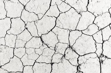 Beyaz kurumuş ve çatlamış toprak arka planı, kuru çatlak zemini, çatlak yüzeyi, beyaz çatlamış dokuyu tasarımcılar için kapatın.