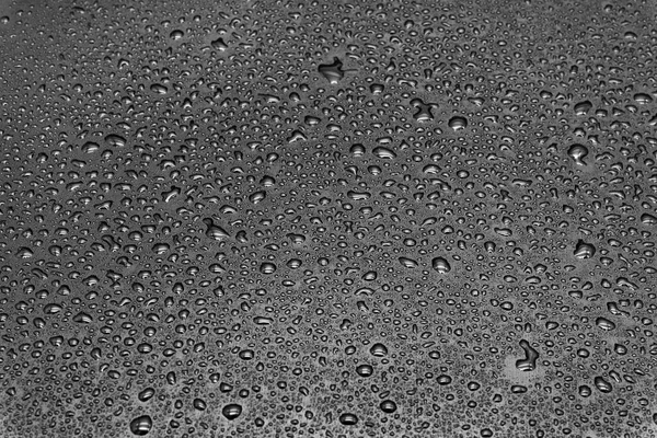 Gri arkaplanda su damlaları, doku yakın plan