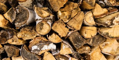 Odunluğa odun yığını, kahverengi ahşap doku ve arka plan, kış için hazırlanmış yakacak odun yığını, istiflenmiş kütük dokusu.