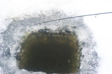 Buzda bir delik, kış balık tutma deliği, buzda bir olta kamışı, kış balıkçılığı.