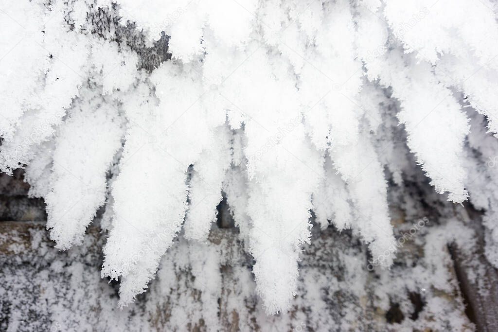 frozen wooden roof with pieces of snow, snow stalactites on the wall, winter, snowy growths, snow icicles
