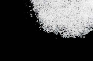 Siyah arka plana beyaz deniz tuzu döküldü. Siyah arkaplanda şeffaf çakıl taşları