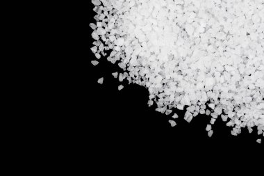 Siyah arka plana beyaz deniz tuzu döküldü. Siyah arkaplanda şeffaf çakıl taşları