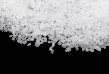 Siyah arka plana beyaz deniz tuzu döküldü. Siyah arkaplanda şeffaf çakıl taşları