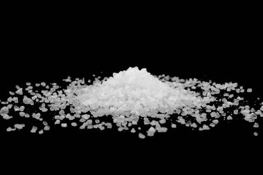 Siyah arka plana beyaz deniz tuzu döküldü. Siyah arkaplanda şeffaf çakıl taşları