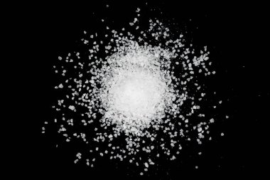 Siyah arka plana beyaz deniz tuzu döküldü. Siyah arkaplanda şeffaf çakıl taşları