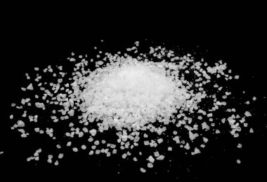 Siyah arka plana beyaz deniz tuzu döküldü. Siyah arkaplanda şeffaf çakıl taşları