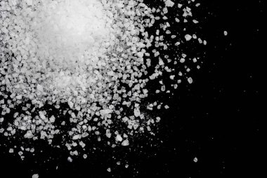 Siyah arka plana beyaz deniz tuzu döküldü. Siyah arkaplanda şeffaf çakıl taşları