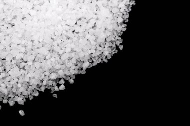 Siyah arka plana beyaz deniz tuzu döküldü. Siyah arkaplanda şeffaf çakıl taşları