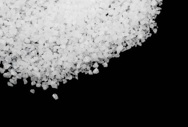 Siyah arka plana beyaz deniz tuzu döküldü. Siyah arkaplanda şeffaf çakıl taşları