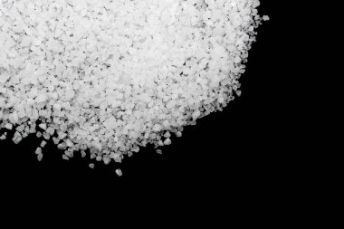 Siyah arka plana beyaz deniz tuzu döküldü. Siyah arkaplanda şeffaf çakıl taşları