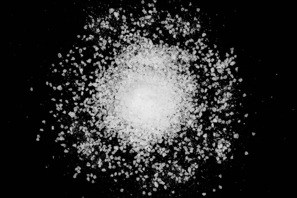 Siyah arka plana beyaz deniz tuzu döküldü. Siyah arkaplanda şeffaf çakıl taşları